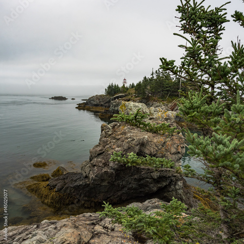 Rocky shoreline with lighthouse on Campobello Island, New Brunswick, Canada