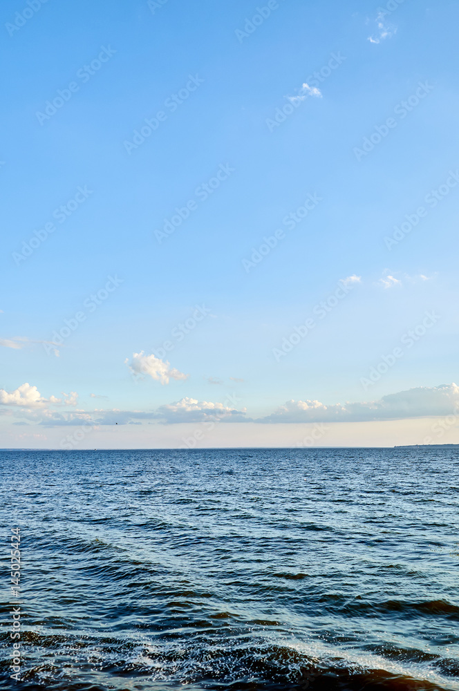 Obraz premium Beautiful sea, river, lake, reservoir. Ukraine, Dnepropetrovsk region, Nikopol city. Natural panorama in the rays of the setting, the rising sun. A magnificent blue sky with neat clouds. 