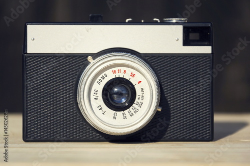 Old vintage filtered camera on wooden background
