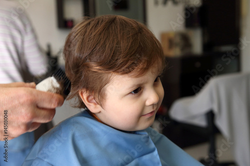 little kid cutting the hair in the barbershop