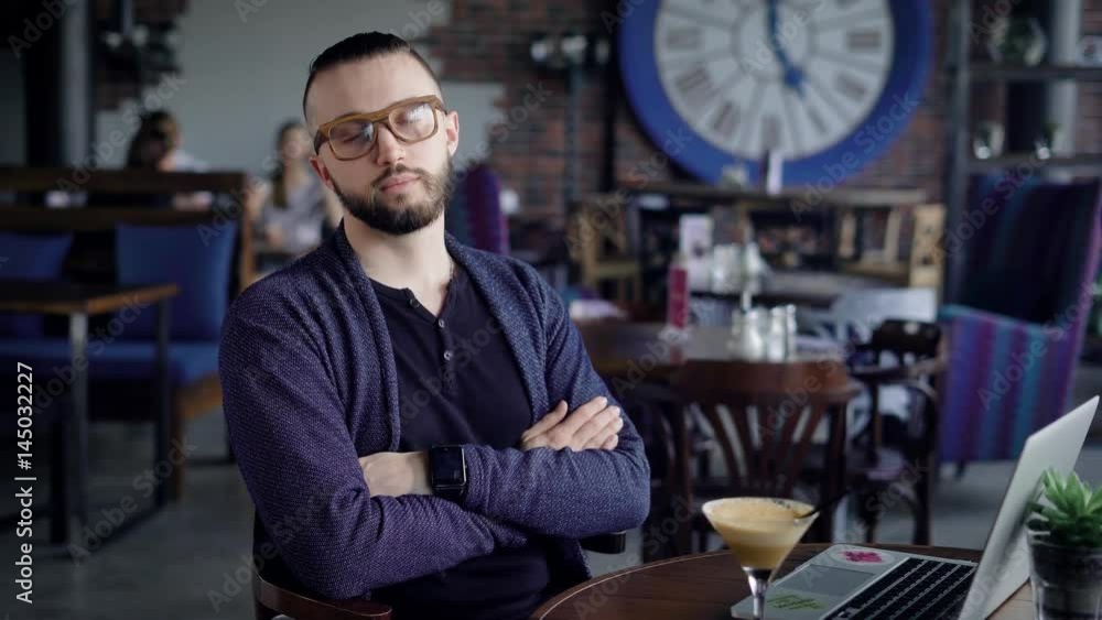 Portrait of an attractive young man in glasses. Hipster in casual clothes looks into the camera with a slight smile. Actually looks guy Portrait of an attractive young man in glasses. Hipster in casual clothes looks into the camera with a slight smile. Actually looks guy