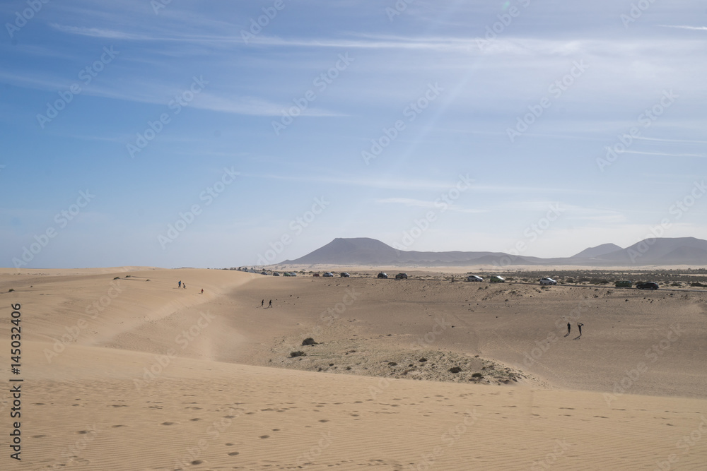 Several cars on the road in the sand dunes 