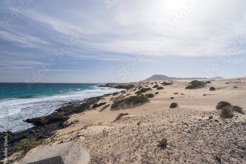 Yellow sand and black stones on the volcanic coastline