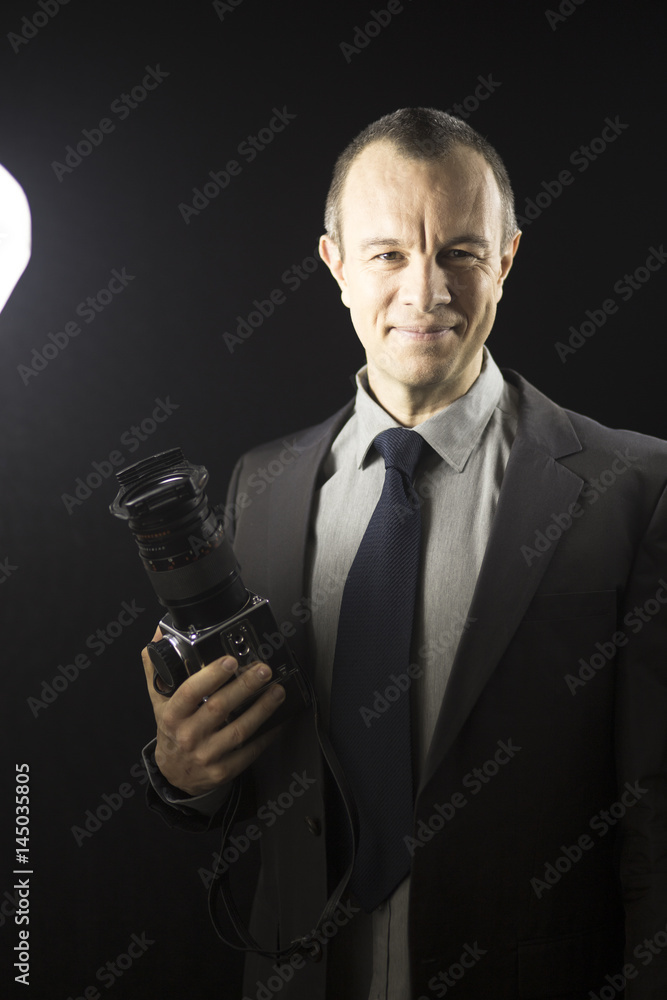 Naklejka premium Photographer in studio in suit