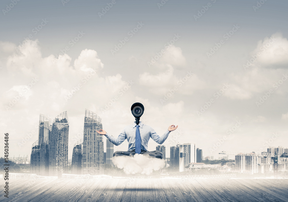 Camera headed man sitting in lotus pose on cloud against modern Camera headed man sitting in lotus pose on cloud against modern