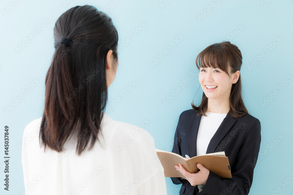 asian businesswomen talking on blue background asian businesswomen talking on blue background