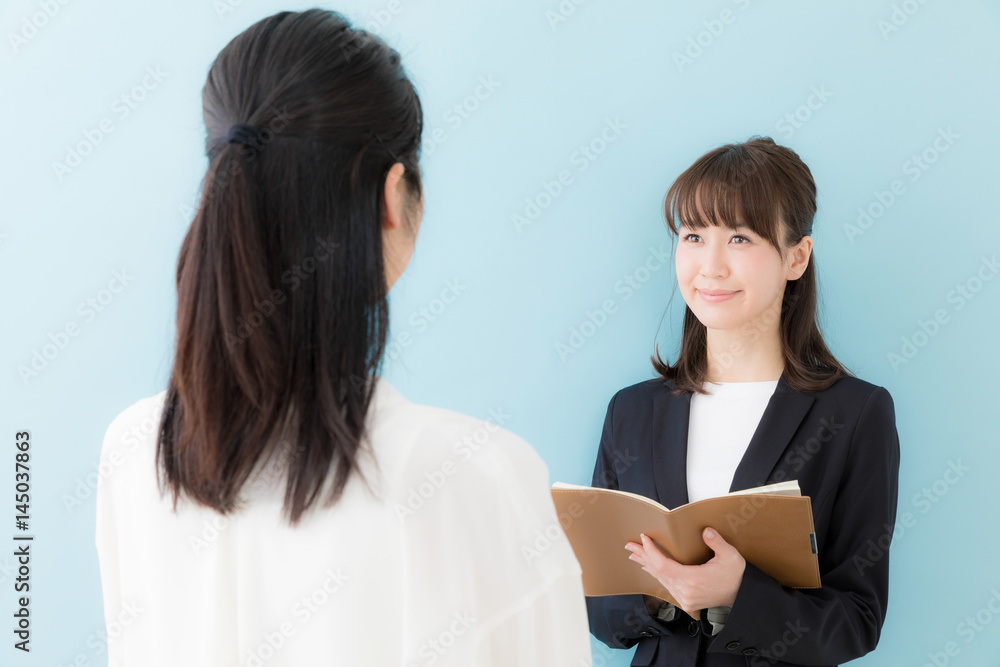 asian businesswomen talking on blue background asian businesswomen talking on blue background