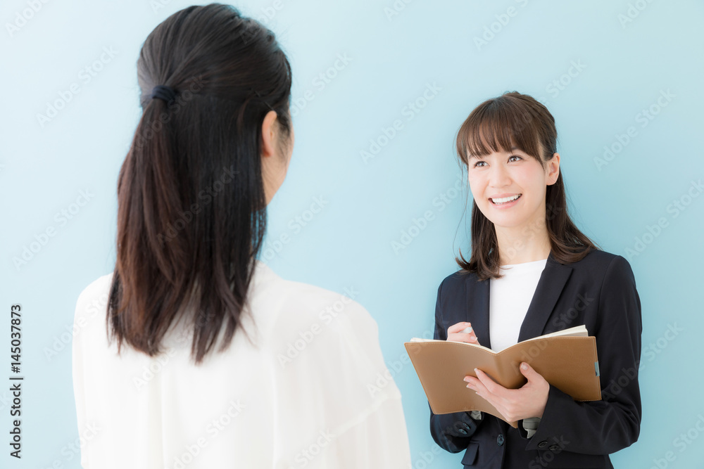 asian businesswomen talking on blue background asian businesswomen talking on blue background