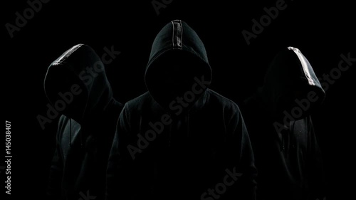 Mysterious hooded man standing in the dark