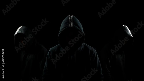Faceless mysterious hooded individuals