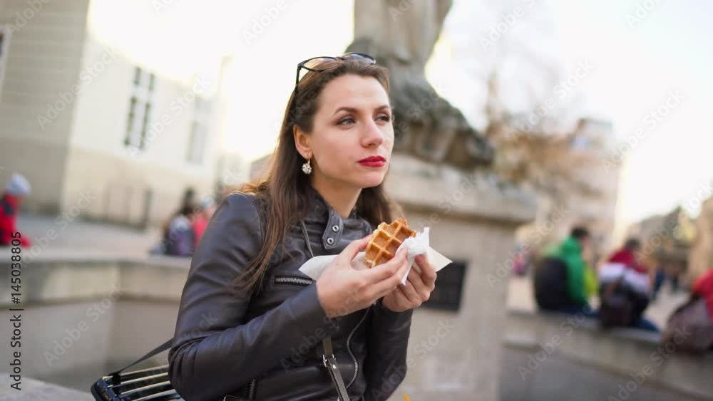 Woman is eating a Viennese waffle on vacation Woman is eating a Viennese waffle on vacation
