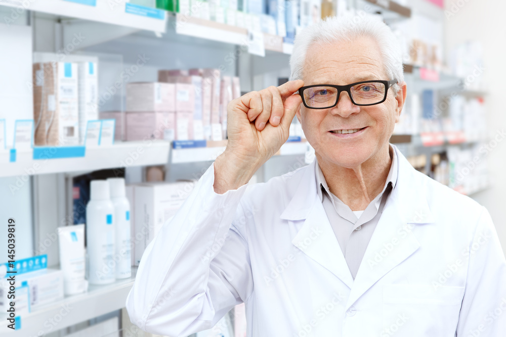 Senior male pharmacist working at his drugstore Senior male pharmacist working at his drugstore