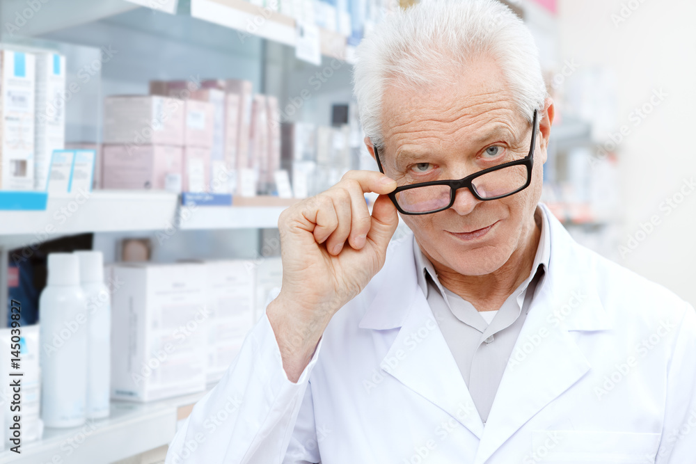 Senior male pharmacist working at his drugstore Senior male pharmacist working at his drugstore
