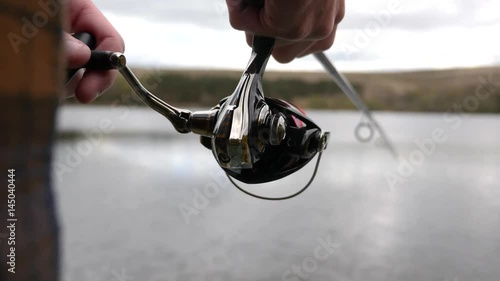 Fisherman reeling in a fish, close up of reel