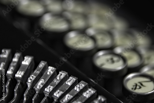 Vintage Keyboarding: Classic 1940's typewriter with bokeh keyboard and black background. Suitable for business offices and hotel rooms that cater to the business clientele.