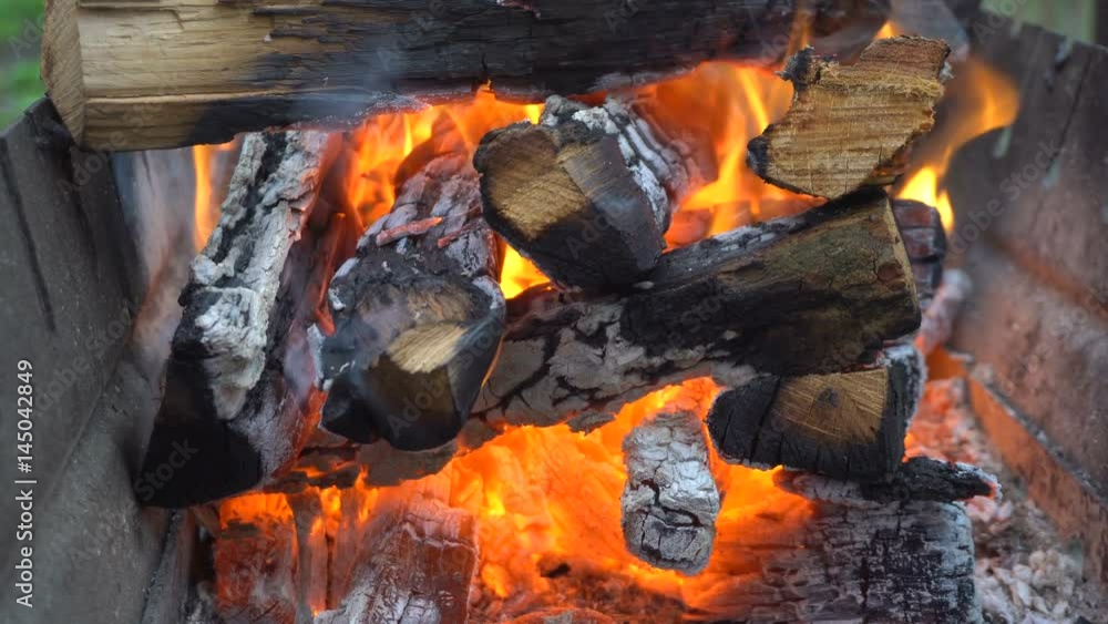 Firewood is burning in the grill. Handheld shooting Firewood is burning in the grill. Handheld shooting