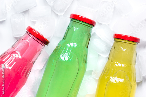 colorful plastic bottles with ice cubes white desk background top view mockup