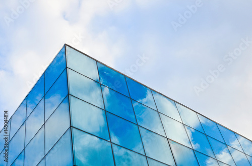 Blue sky with white clouds reflected in the windows. Abstract background for business purposes.