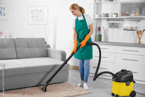 Cuadro en lienzo Woman cleaning carpet with vacuum cleaner