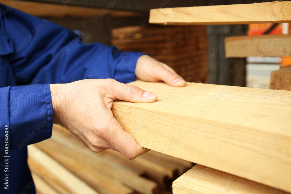 Carpenter with wooden planks in workshop, closeup Carpenter with wooden planks in workshop, closeup