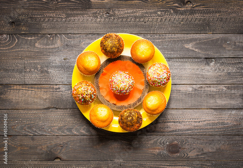 Delicious homemade muffins with yogurt, on a wooden background with space for text.