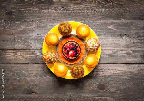 Delicious homemade muffins with yogurt, on a wooden background with space for text.