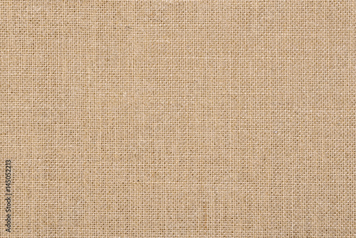A background of a scratchy burlack material in an even light brown color. photo