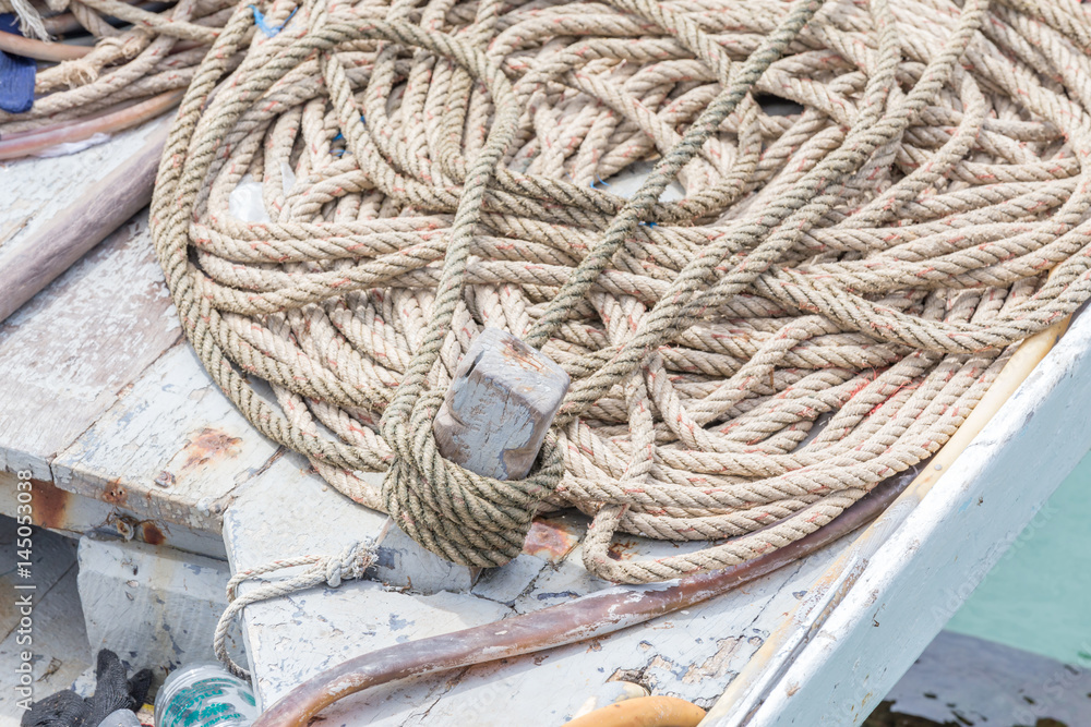 Mooring rope tied with anchor of wooden dock.