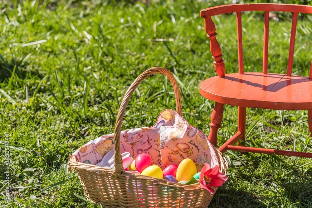 little orange chair and easter basket in field of tall grass little orange chair and easter basket in field of tall grass