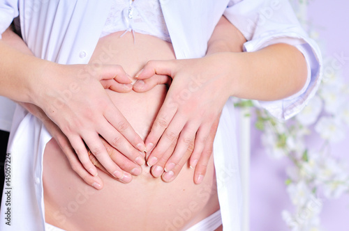 Wallpaper Mural Pregnant woman and husband holding hands in heart shape Torontodigital.ca