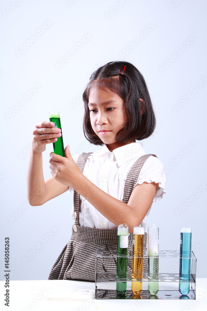 Little girl holding a test tube with liquid Scientist chemistry and science education concept Little girl holding a test tube with liquid Scientist chemistry and science education concept