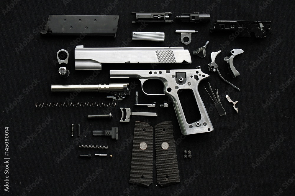 Disassembled handgun on black background,