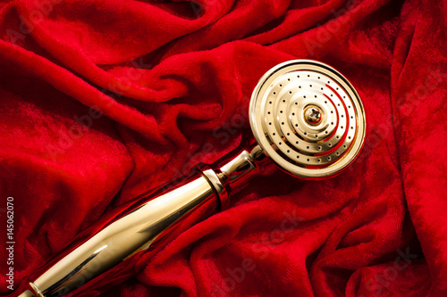 Vászonkép Golden showerhead wrapped in red velvet