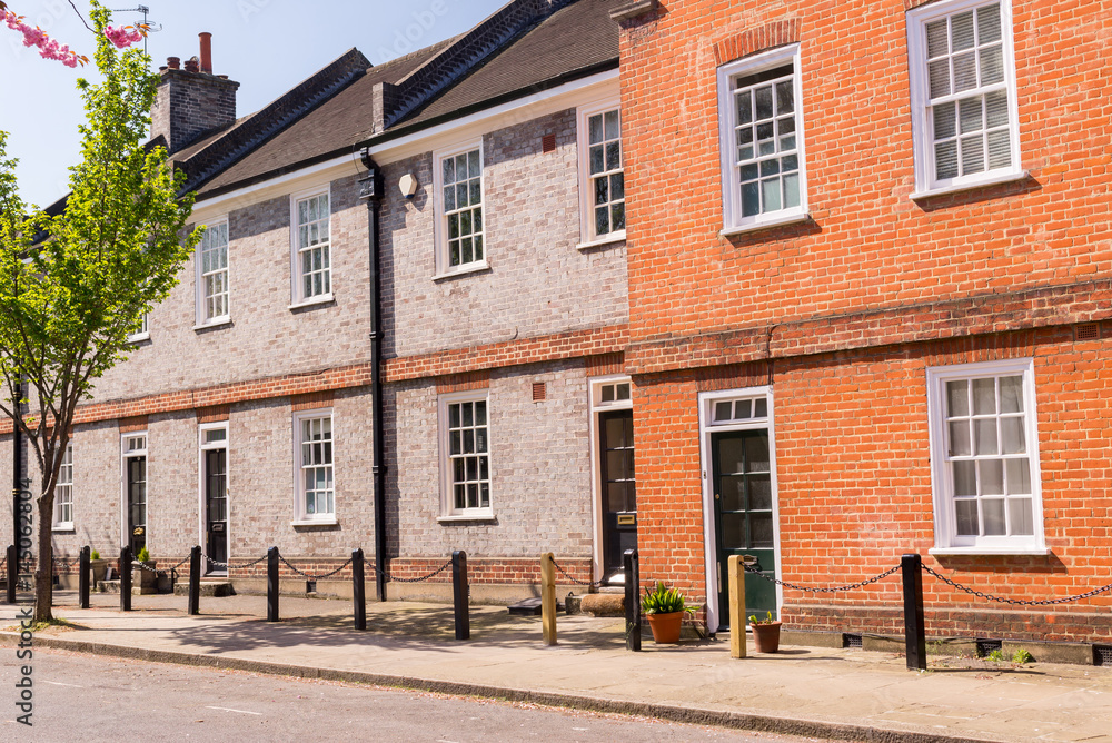 Classic British  restored Edwardian brick houses on a local road with tree growing on the pavement