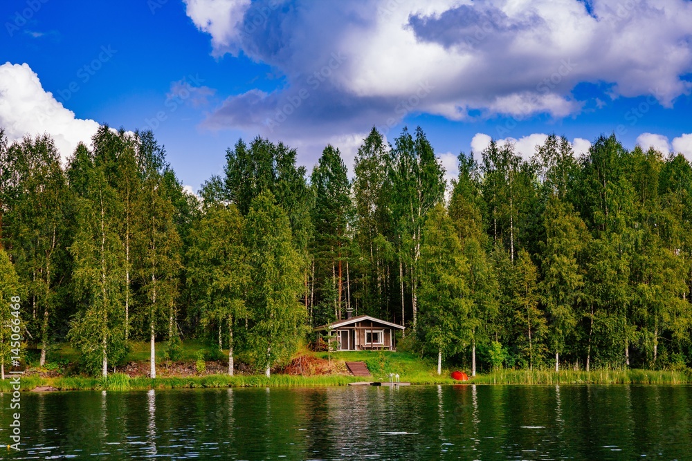 Wooden sauna log cabin at the lake in summer in Finland
