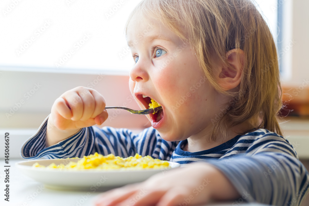 open mouth child with an appetite eats millet porridge open mouth child with an appetite eats millet porridge