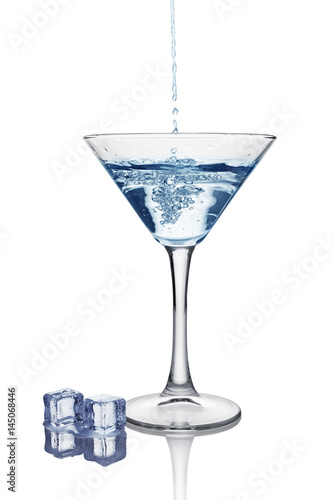 Blue splash in glass of white transparent alcoholic cocktail drink with ice cube