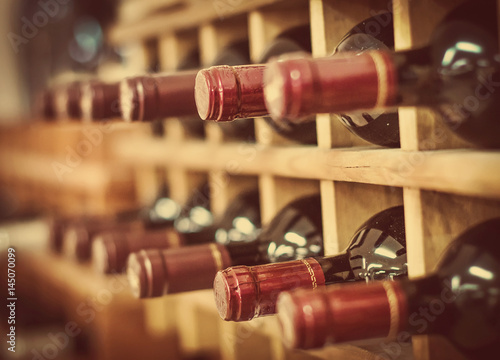 Red wine bottles stacked on wooden racks