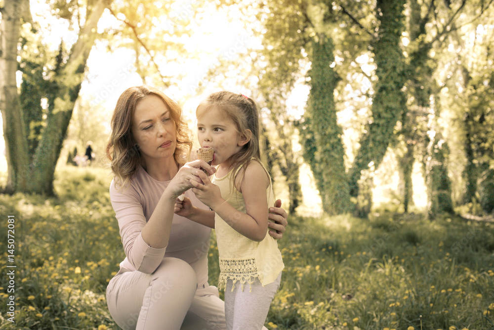 Mother and daughter in the meadow with ice cream. Mother and daughter in the meadow with ice cream.