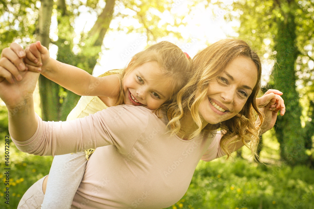 Fototapeta premium Mother and daughter outdoors in a meadow.