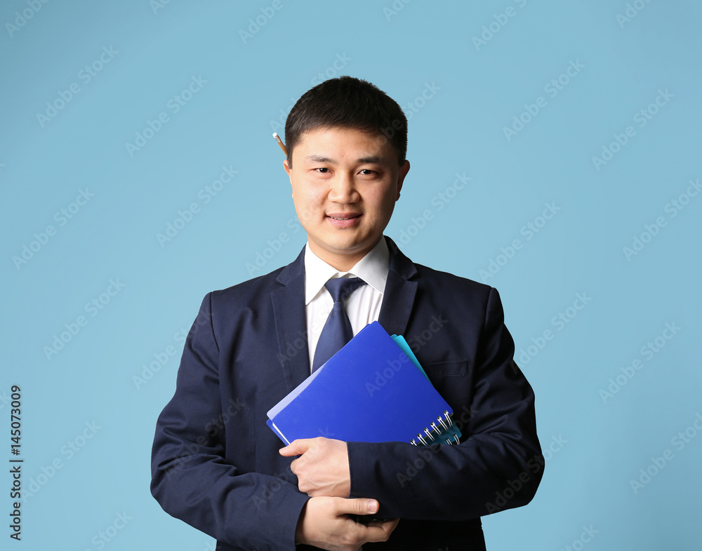 Handsome young Asian teacher on light background Handsome young Asian teacher on light background