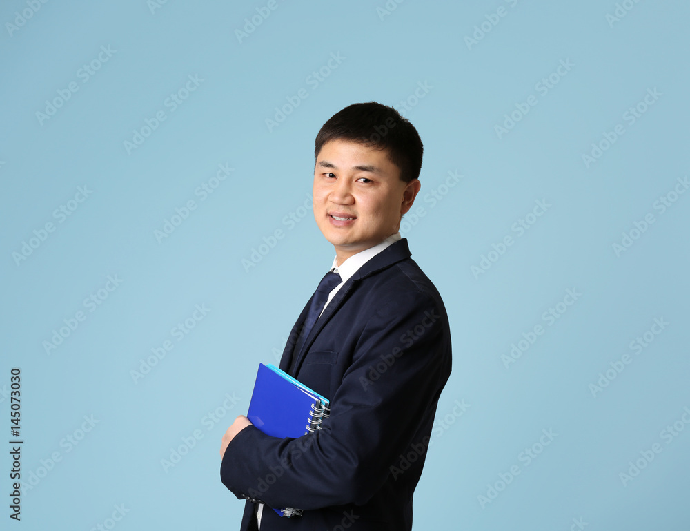 Handsome young Asian teacher on light background Handsome young Asian teacher on light background