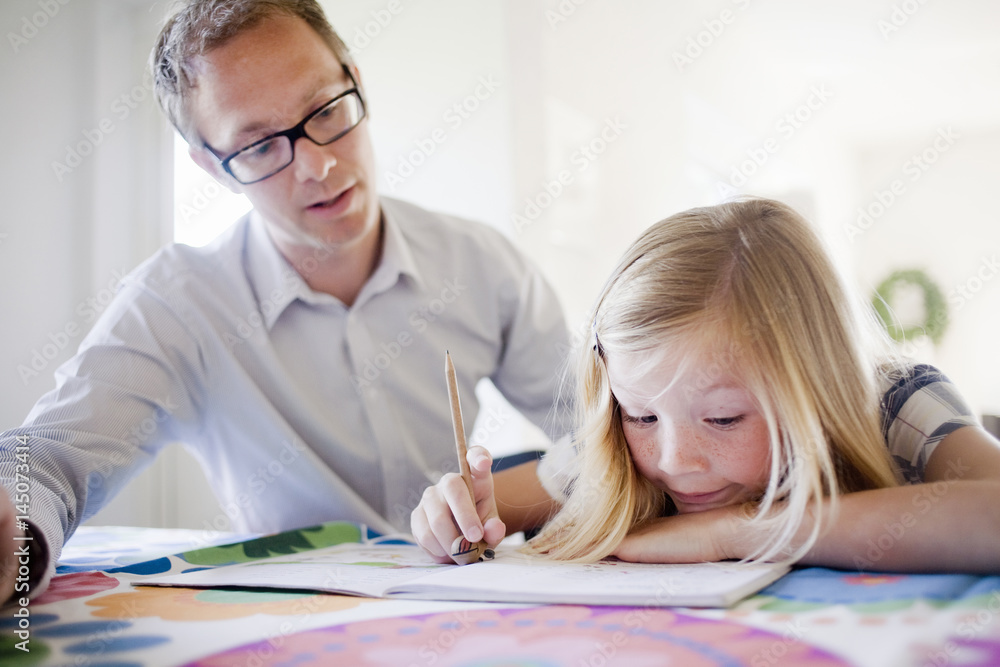 Father helping daughter with homework Father helping daughter with homework