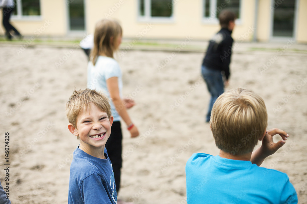 Portrait of happy schoolboy playing with friends at playground Portrait of happy schoolboy playing with friends at playground