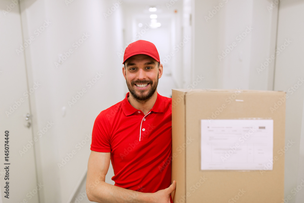 delivery man with parcel box in corridor delivery man with parcel box in corridor
