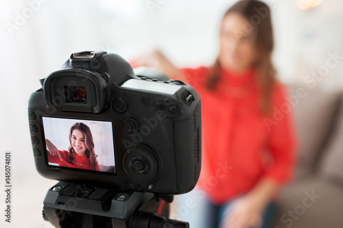 woman with camera recording video at home