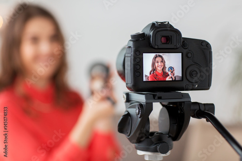 woman with bronzer and camera recording video