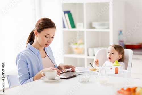 happy mother and baby having breakfast at home