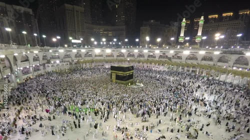 Time lapse video of Muslim pilgrims circling around the holy Kaaba at night during Hajj inside al Masjid al Haram in Mecca, Saudi Arabia. Camera zooms in through the Kaaba.