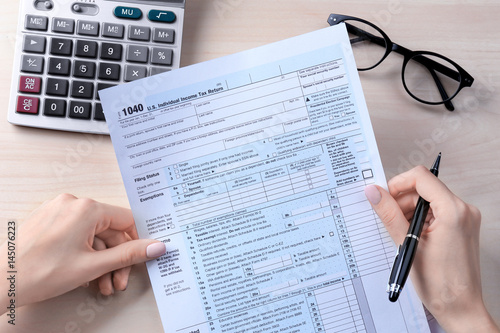 Woman holding individual income tax form, closeup